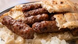 Cevapi with onions and bread. Cevapi, Cevapcici, traditional Balkan food – delicious minced meat.
