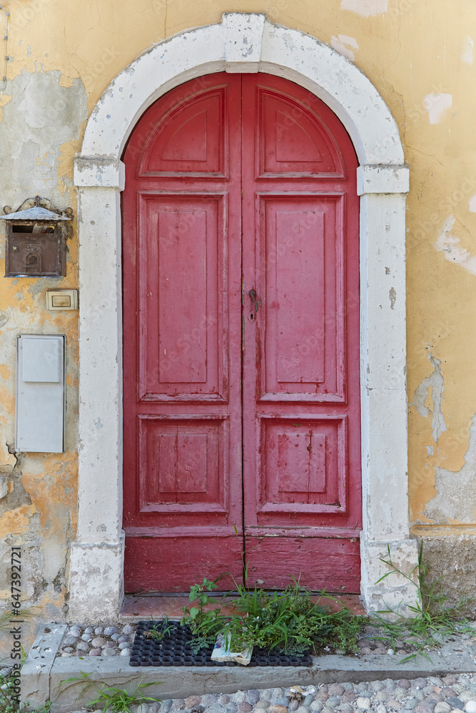 Detail of an old entrance door on an abandoned building in Tuscany, Italy.