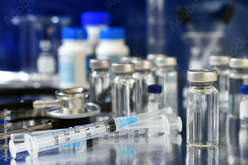 Vaccine booster tripledemic concept background - vials of generic vaccines with syringe and stethoscope photo