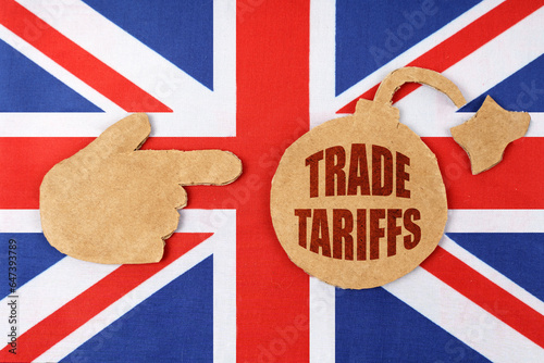 On the flag of Great Britain there is a bomb cut out of cardboard and a sign with the inscription - trade tariffs photo