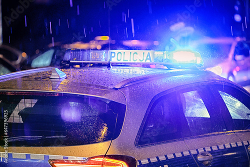Policja polska radiowóz w akcji na ulicy w ruchu. Policja w deszczu. 