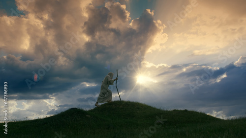 Tableau sur toile Jesus Christ silhouette ascending a hill shrouded in twilight.