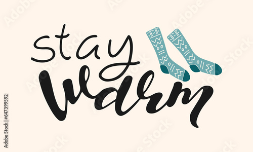Stay warm handwritten lettering phrase. Seasonal composition with hand drawn inscription and warm socks. Winter autumn cozy background. Design element