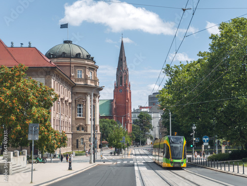 Obraz na płótnie Summer cityscape of Poznań, Wielkopolska, Poland. In the photo: Modern tram at Fredry street, building of Adam Mickiewicz University in Poznan (WFPiK UAM), catholic church and Okrąglak building. w salonie