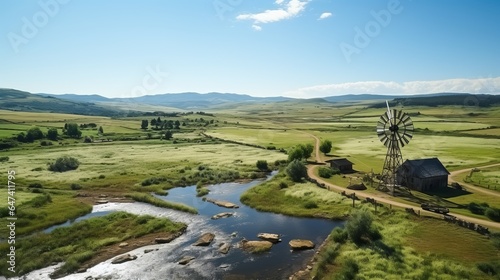 Landscape with a chamomile field and a river near a windmill. Summer atmosphere with clean area without people and animals