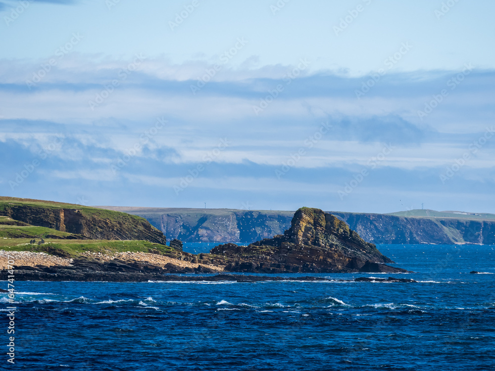 Large rock on the seashore in Orkney, Scotland with flock of white seabirds Large rock on the seashore in Orkney, Scotland with flock of white seabirds