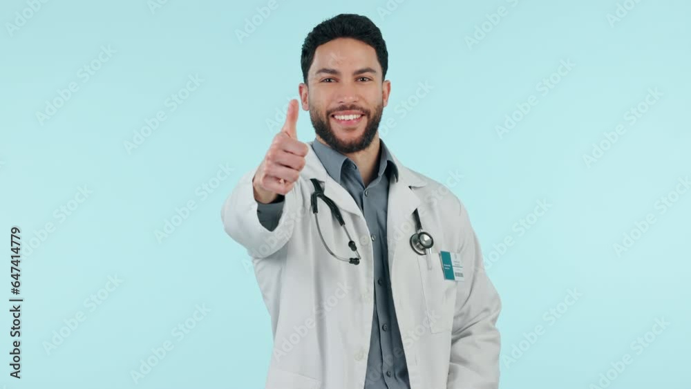 Man, doctor and thumbs up, success or healthcare support, thank you and like emoji in studio. Happy face of medical worker with yes, ok and good job emoji for hospital services on a blue background