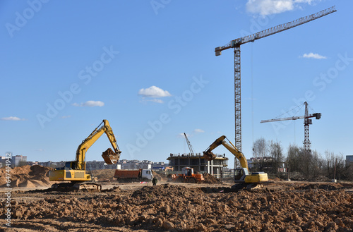 Excavator dig ground at construction site. Dig foundation. Construction of residential buildings and renovation. Earthmover on groundwork. Excavator on earthmoving. Loader on dredging and trenching.