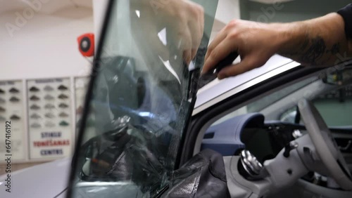 Applying tinting foil on a car window	
