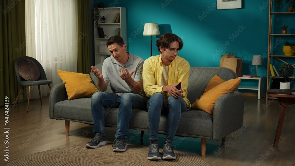 Full-size shot of a homosexual couple. One tries to discuss the issue, explain himself calmly to his partner, who seems jealous, stressed about something he discovered. Full-size shot of a homosexual couple. One tries to discuss the issue, explain himself calmly to his partner, who seems jealous, stressed about something he discovered.