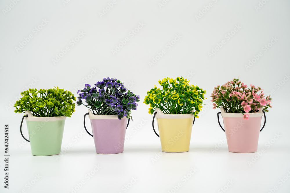 Miniature artificial flowers in pots isolated on white background