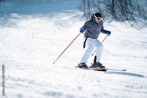 Canvas Print Confident skier skiing downhill in high mountains