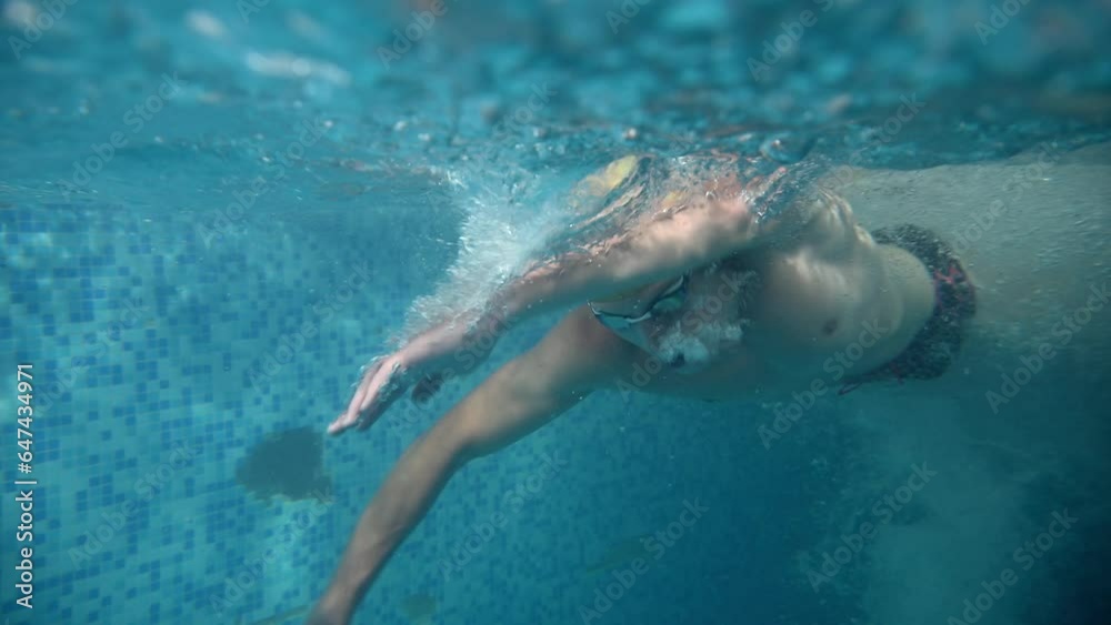 Underwater view of professional swimmer training in swimming pool, 4k 120 fps super slow motion raw video. Triathlete swim in black wetsuit Underwater view of professional swimmer training in swimming pool, 4k 120 fps super slow motion raw video. Triathlete swim in black wetsuit