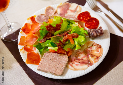 Plate with a delicious Catalan salad of smoked meats  sausage  lettuce  tomatoes and meat.
