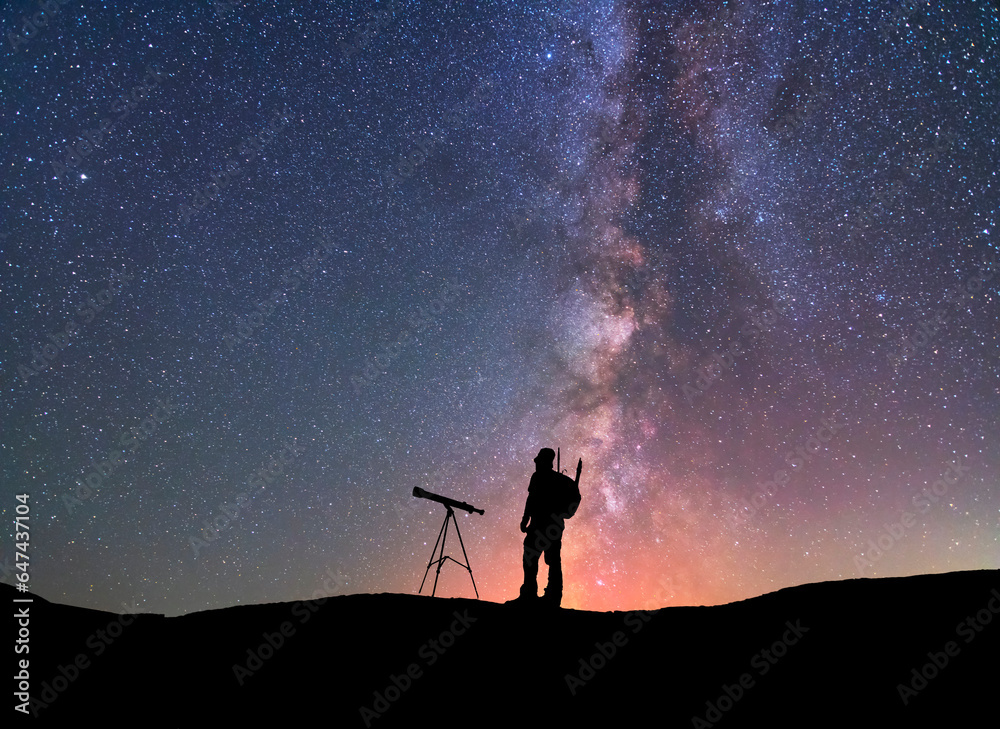 Fantasy landscape, two hiker standing on the hill, and looking at the Milky Way galaxy with telescope.
