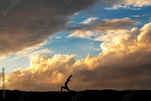 Woman silhouette dancing in the night, on the bright  sunset background.