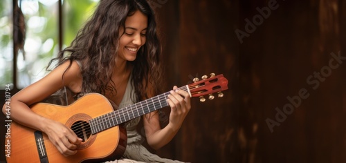A young pretty woman playing guitar, free copy space 