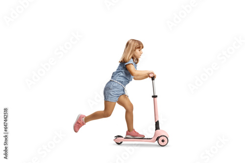 Full length profile shot of a girl riding a pink scooter