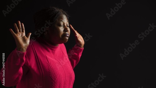 Young lady making I dont know gesture, lifting her shoulders implying confusion and uncertainty. Being ignorant and insecure with perplexed and bewildered reaction in isolated black background.