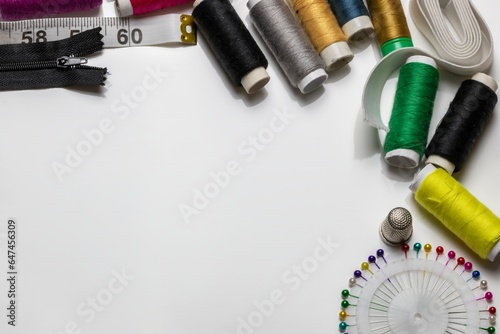 Copy space frame with sewing tools and accessories on white background.