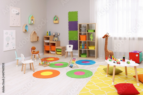 Child`s playroom with different toys and furniture. Cozy kindergarten interior © New Africa