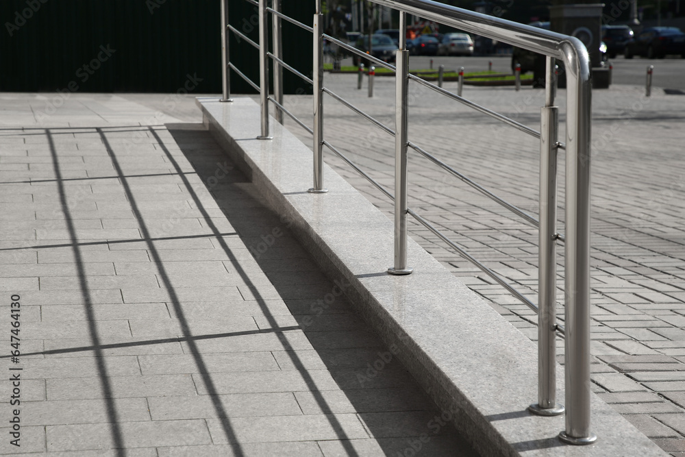 Ramp with metal handrail near building outdoors