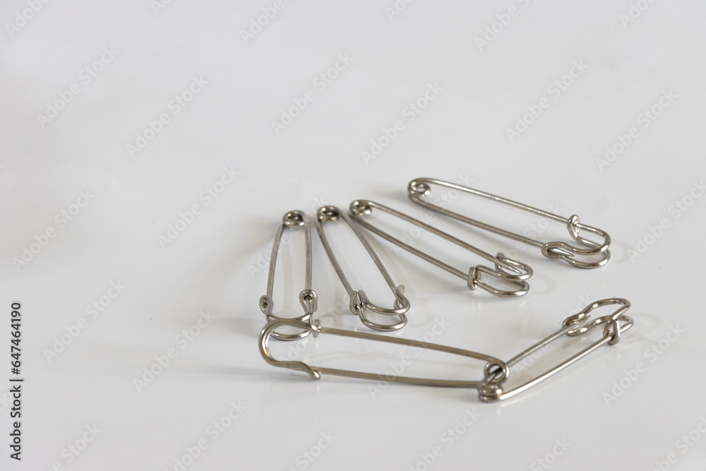 Conjunto de alfileres imperdibles de metal cromado, sobre superficie gris