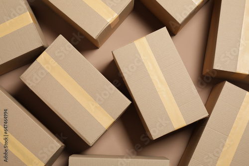Many cardboard boxes on light brown background, flat lay