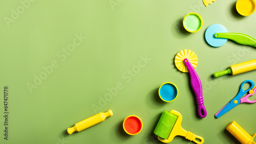 Plasticine or clay play dough tools activity set for children on a green background. Molding stack, shape, and rolling pin for education in school or kindergarten.
