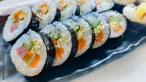 Close up of a gimbap served in a black long plate, a popular traditional authentic South Korean dish