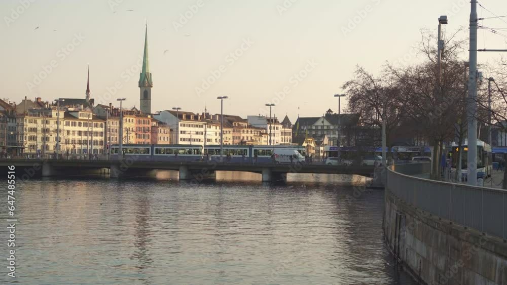 Zurich, Switzerland, 6 February 2023: Tram passing over the Limmat river bridge in Zurich's old town at sunset. Zurich, Switzerland, 6 February 2023: Tram passing over the Limmat river bridge in Zurich's old town at sunset.