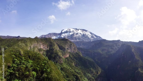 4K Drone footage capturing Mount Kilimanjaro and its surrounding valleys and forests. Nature, environment, exploration, hiking concept.