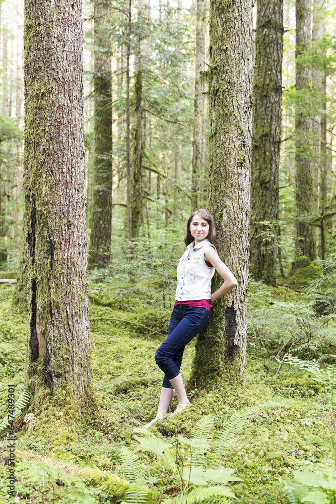 Portrait Of A Teenage Girl Leaning Against A Tree In A Forest; Chilliwack, British Columbia, Canada Portrait Of A Teenage Girl Leaning Against A Tree In A Forest; Chilliwack, British Columbia, Canada