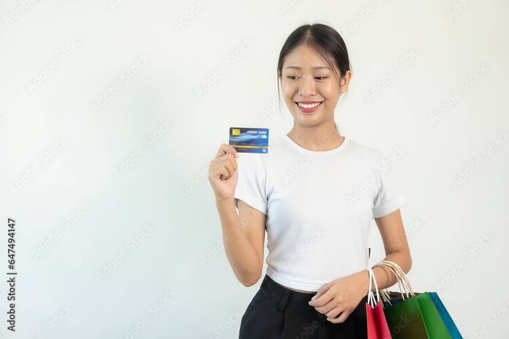 Asian woman holding credit card and shopping bag white background Online banking transaction concept in online shopping Asian woman holding credit card and shopping bag white background Online banking transaction concept in online shopping