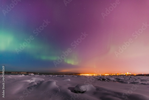 Northern lights shine above city skyline in this nighttime view from the tony knowles coastal trail in winter; Anchorage alaska united states of america photo