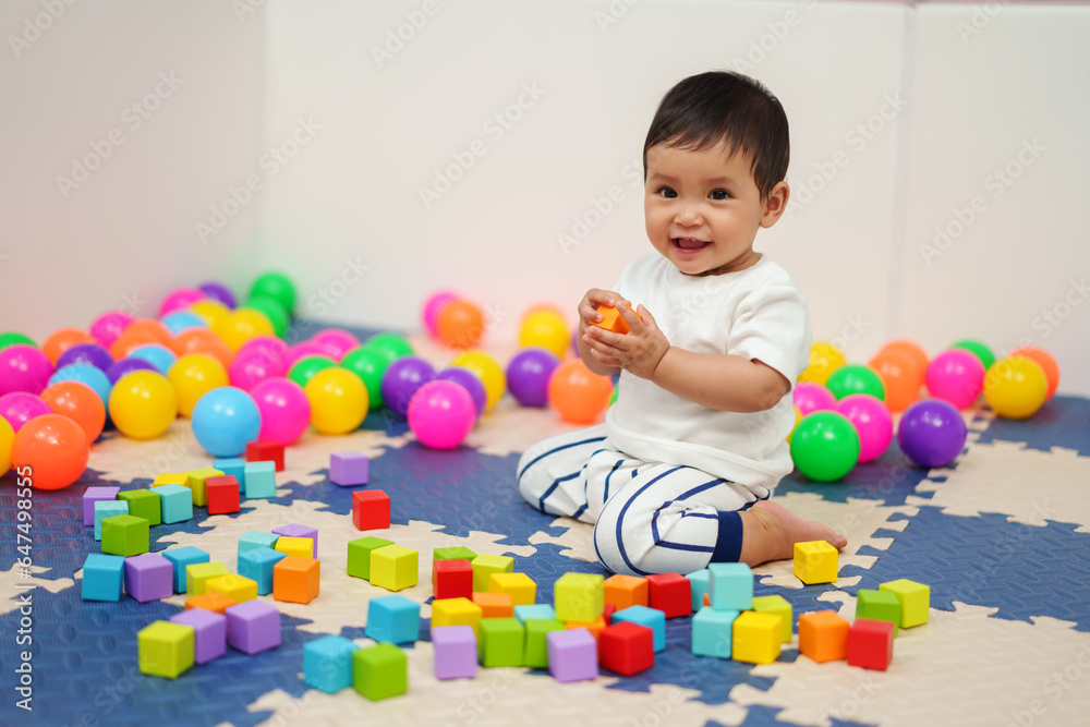 happy infant baby playing wooden block toy in playpen happy infant baby playing wooden block toy in playpen