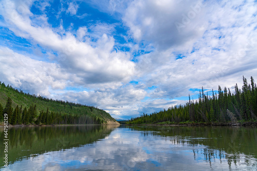 Calm conditions on the Yukon River create the perfect environment for a reflection on a beautiful summer evening in the Yukon; Whitehorse, Yukon Territory, Canada