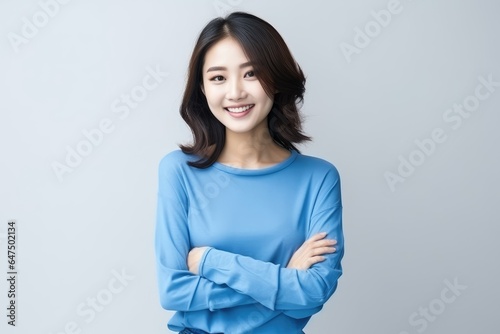 Portrait of an Asian woman with white wall background.