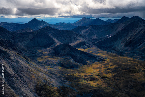 Aerial view of rugged mountain peaks and a valley with tundra in autumn colours in Tombstone Territorial Park along the Dempster Highway in the Yukon Territory; Yukon, Canada photo