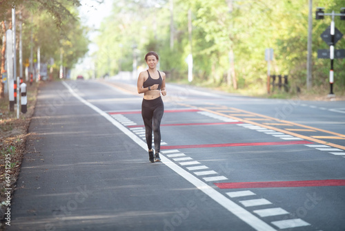 Wallpaper Mural young fitness woman runner athlete running at road. athlete woman in running start pose on city street. sport tight clothes. bright sunset, horizontal. Healthy woman on morning road workout jogging. Torontodigital.ca