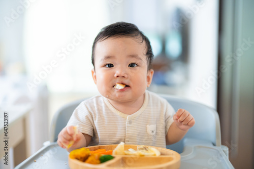 Fotografia 離乳食後期でをつかみ食べをしてご機嫌な生後9か月の赤ちゃん