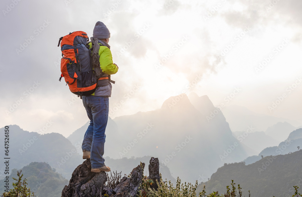 Obraz premium Hiker with backpack standing on top mountain sunset background. Hiker man hiking living healthy active lifestyle.