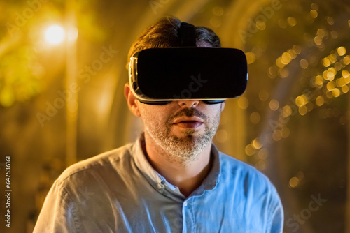 Man in VR glasses inside a glamping tent at night