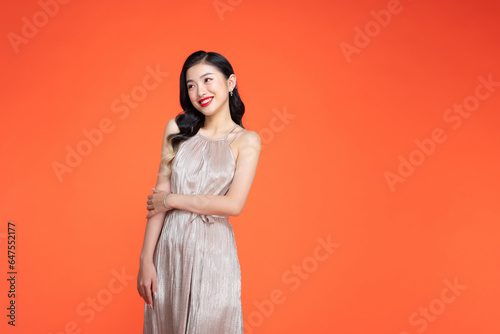 sexy girl dancing in the studio on a red background in a shiny dress