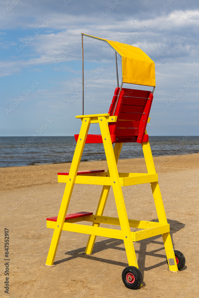 Empty lifeguard chair on the sea beach. Lifeguard equipment to support the observation of people playing in the water. Photo taken at noon on a sunny day Empty lifeguard chair on the sea beach. Lifeguard equipment to support the observation of people playing in the water. Photo taken at noon on a sunny day