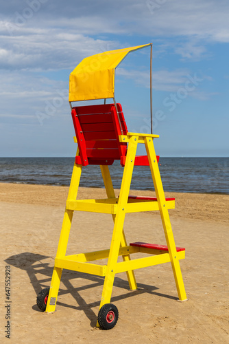 Empty lifeguard chair on the sea beach. Lifeguard equipment to support the observation of people playing in the water. Photo taken at noon on a sunny day