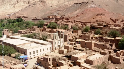 Adobe Tuyoq village in Taklamakan desert. Aerial dolly out photo