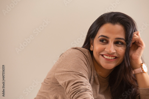 A YOUNG WOMAN LOOKING AWAY FROM CAMERA AND SMILING photo