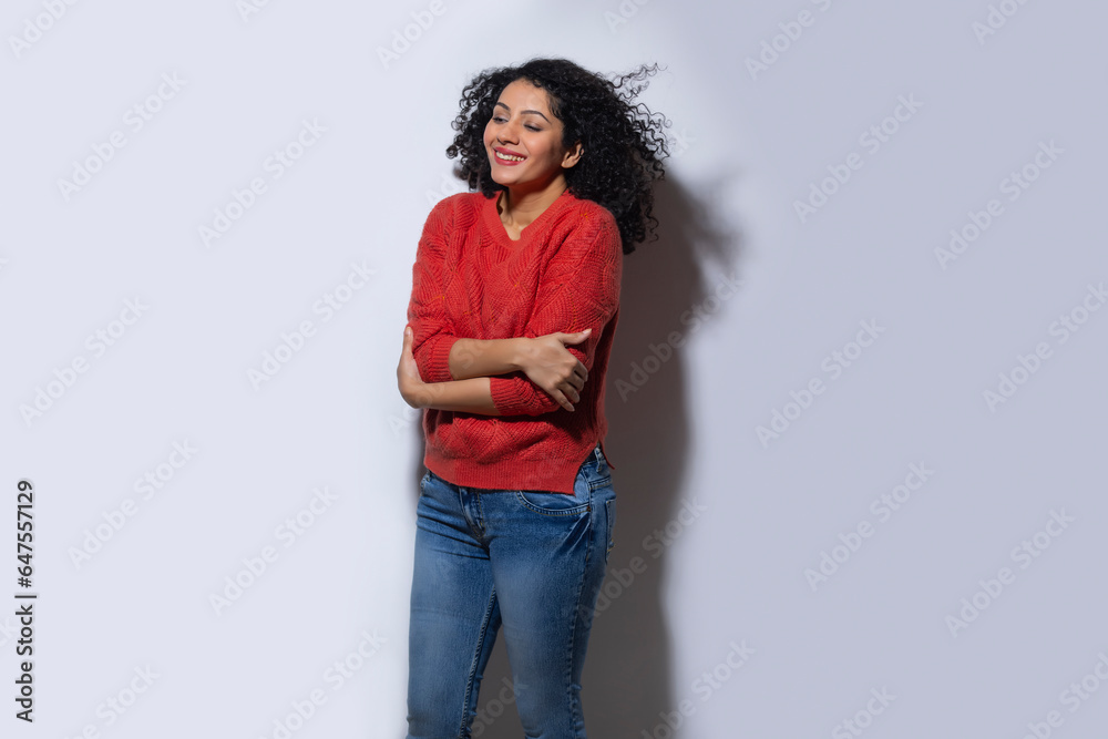 Young woman in red sweater standing with crossed hands Young woman in red sweater standing with crossed hands