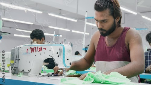 Skilled Indian men or male workers, artisans, or tailors busy working on the sewing machine in a busy textile workshop or the garment industry or factory, Jaipur, India